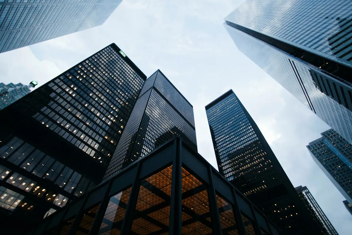 Looking up at glass corporate skyscrapers against the sky