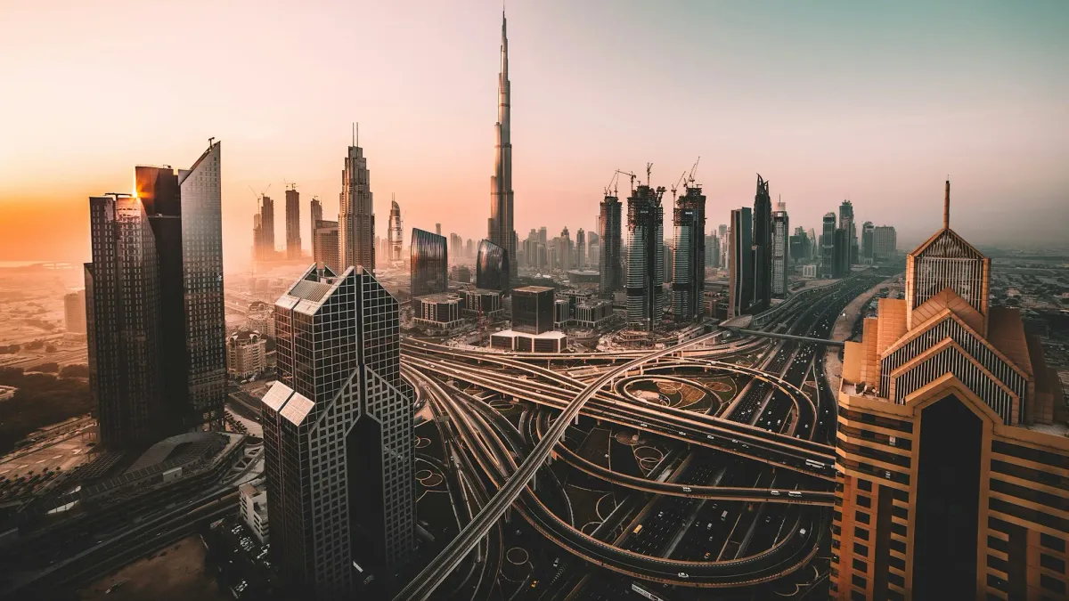 Dubai skyline and highway interchange under an orange sunset haze