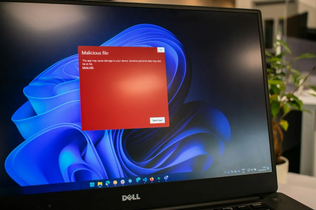A laptop glowing with a red warning screen, a red flag for web3 job scams