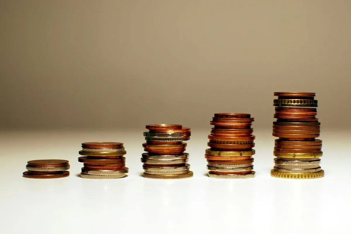 Rising stacks of coins on a purple background, illustrating growing web3 developer salaries