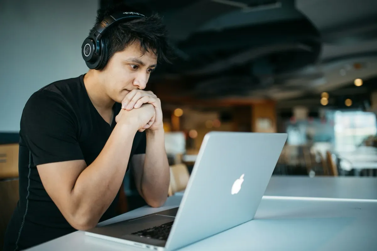 A person with headphones focused at a laptop, breaking into web3 without a degree