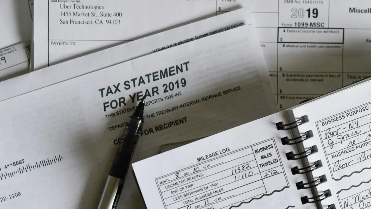 Stacked tax statements and forms with a pen on a desk
