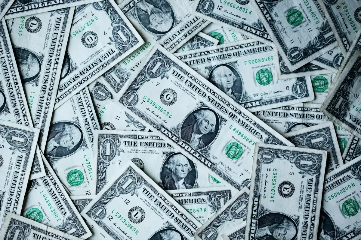 Scattered US dollar bills covering a flat surface