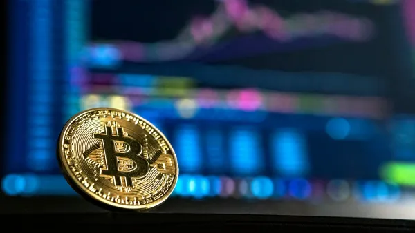 Gold bitcoin coin standing in front of a glowing trading chart