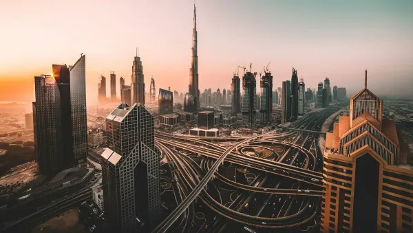 Dubai skyline and highway interchange under an orange sunset haze