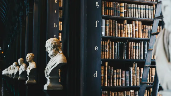 Dim law library shelves lined with old books and stone busts