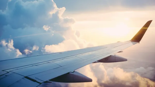 Airplane wing above the clouds during a golden sunset