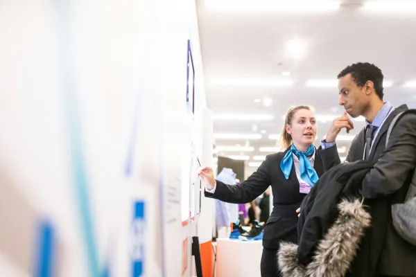 Two professionals reviewing information at a conference, a start in entry-level crypto jobs