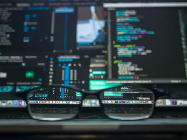 Code reflected in a pair of eyeglasses, comparing web3 and traditional tech jobs