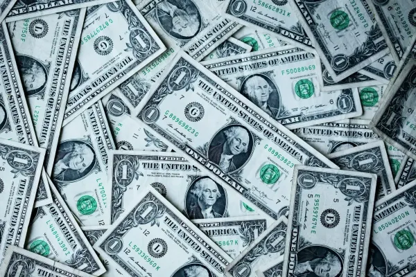 A dense pile of US one-dollar bills, representing the highest-paying web3 jobs