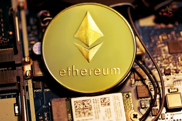 Gold Ethereum coin resting on a computer circuit board