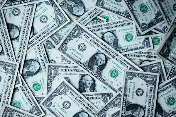Scattered US dollar bills covering a flat surface