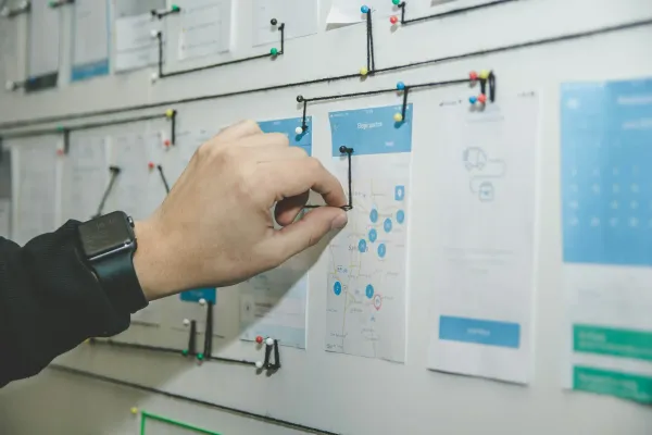 Hand pinning task cards to a project planning board